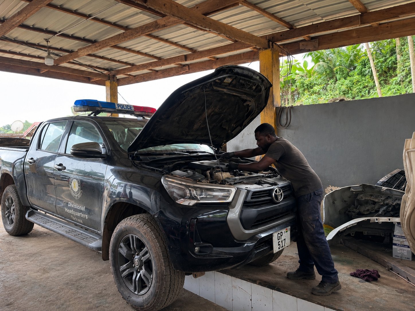 Technician servicing a vehicle under the open hood